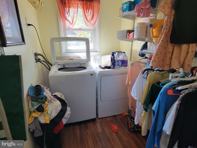 clothes washing area with washer and clothes dryer and dark hardwood / wood-style floors