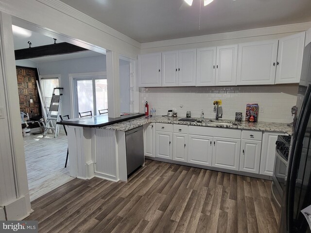 kitchen featuring kitchen peninsula, dark hardwood / wood-style flooring, dishwasher, white cabinets, and a breakfast bar area