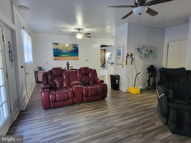 living room with dark hardwood / wood-style floors, ceiling fan, and plenty of natural light