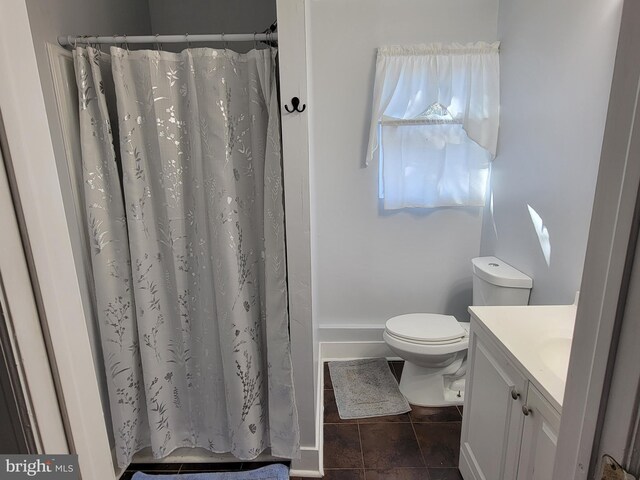 bathroom with tile patterned flooring, vanity, curtained shower, and toilet