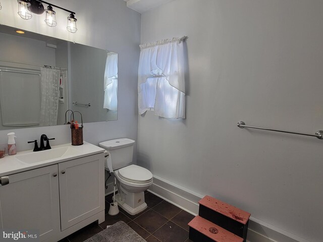 bathroom featuring tile patterned flooring, vanity, and toilet