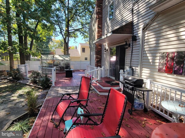 wooden deck featuring area for grilling and an outdoor structure