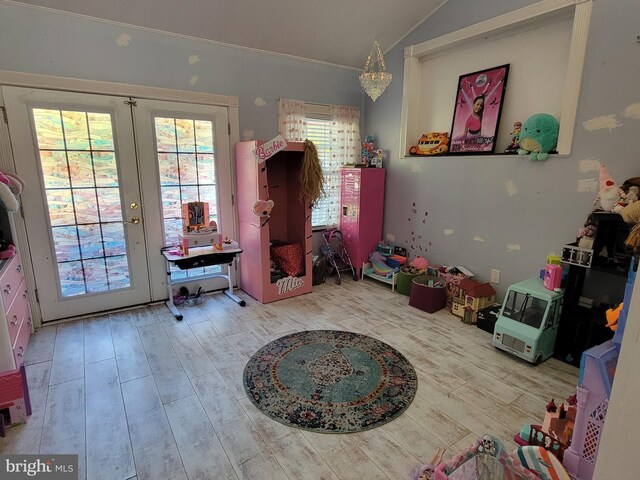 interior space with french doors, light hardwood / wood-style flooring, and lofted ceiling