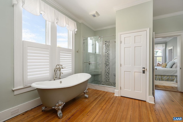 bathroom featuring a wealth of natural light, hardwood / wood-style floors, and separate shower and tub