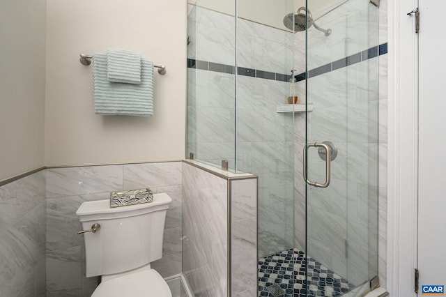 bathroom with tile walls, walk in shower, and toilet