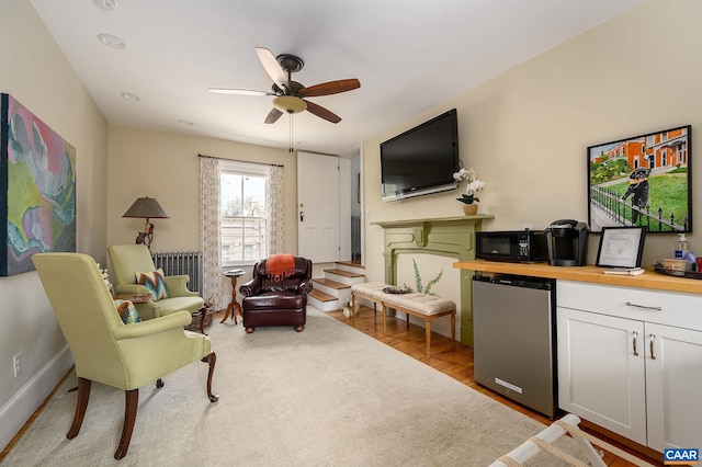 living room with ceiling fan, light hardwood / wood-style flooring, and radiator heating unit