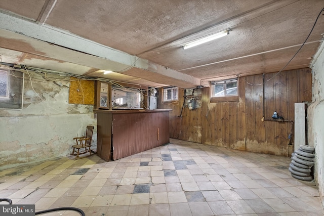 basement with wooden walls and light tile flooring