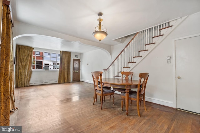 dining area with a baseboard heating unit and wood-type flooring