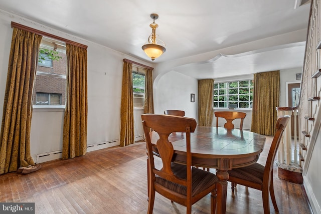 dining room with a baseboard heating unit and hardwood / wood-style floors