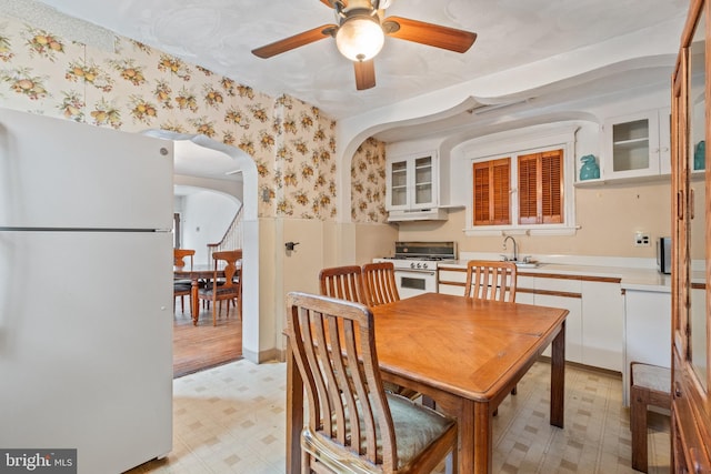 dining area with ceiling fan, sink, and light tile flooring