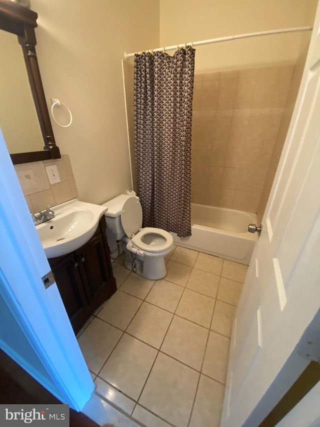 full bathroom featuring tasteful backsplash, shower / bath combination with curtain, tile floors, toilet, and vanity