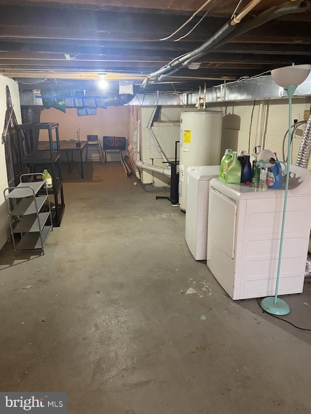 basement featuring water heater and washing machine and dryer