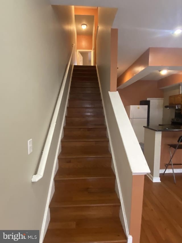 staircase with dark hardwood / wood-style floors