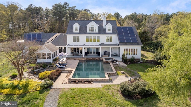 rear view of house featuring a patio and solar panels