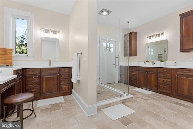 bathroom with an enclosed shower, vanity, and a wealth of natural light