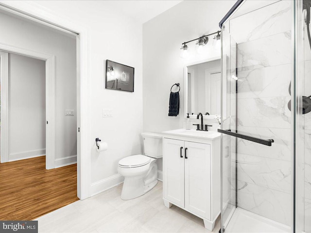 bathroom featuring a shower with door, toilet, tile floors, and large vanity