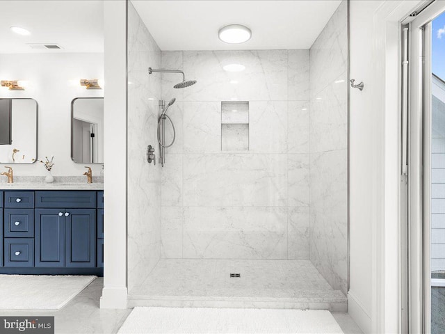 bathroom with a tile shower, oversized vanity, and tile floors