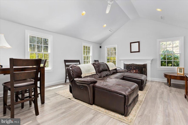 living room featuring high vaulted ceiling and light wood-type flooring