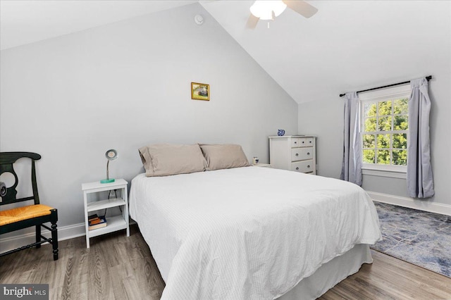 bedroom with ceiling fan, vaulted ceiling, and wood-type flooring