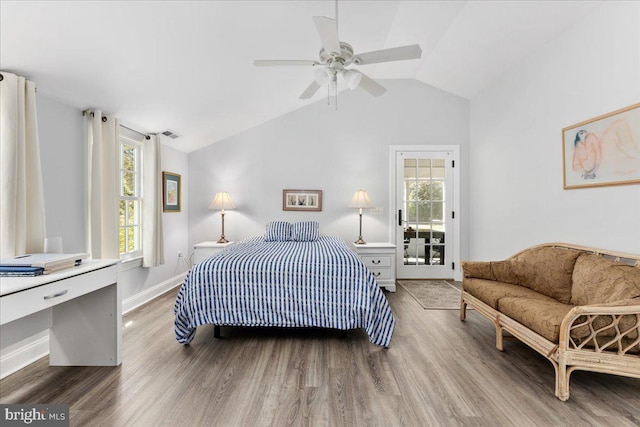 bedroom featuring multiple windows, lofted ceiling, and wood-type flooring