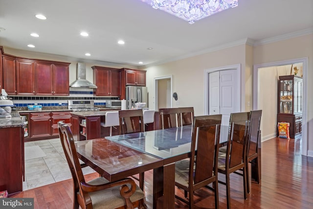 dining space with light wood-type flooring and crown molding