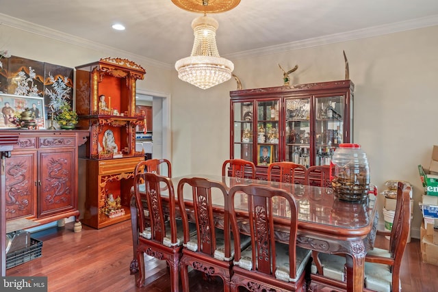 dining room with a chandelier, hardwood / wood-style flooring, and crown molding