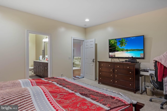 bedroom featuring light carpet and ensuite bath