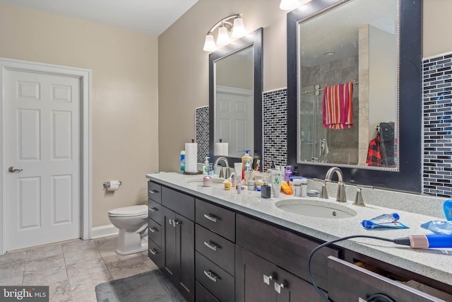 bathroom with tile flooring, oversized vanity, toilet, and double sink