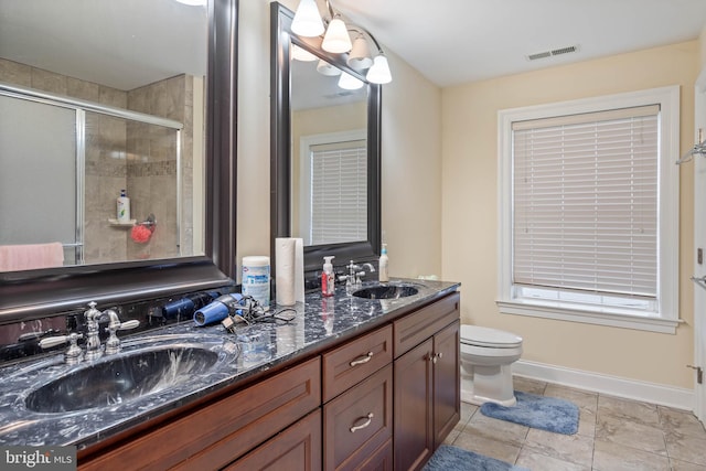 bathroom with tile flooring, oversized vanity, toilet, and dual sinks