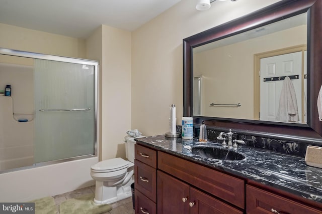 full bathroom with enclosed tub / shower combo, tile floors, oversized vanity, and toilet