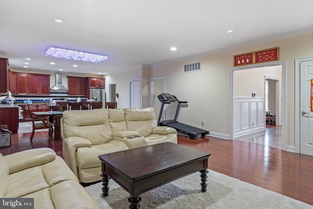 living room featuring wood-type flooring and crown molding