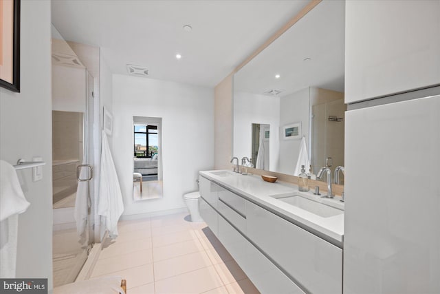 bathroom featuring vanity with extensive cabinet space, toilet, tile flooring, an enclosed shower, and double sink