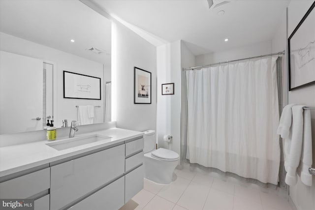 bathroom featuring tile floors, large vanity, and toilet