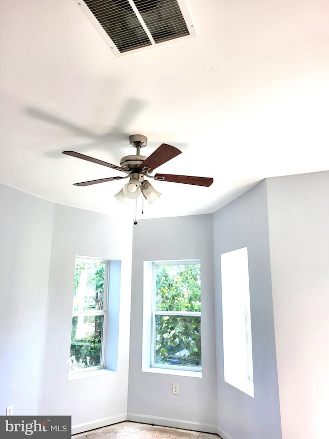 unfurnished room featuring ceiling fan and a healthy amount of sunlight