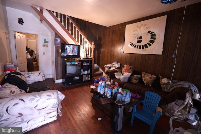 living room with lofted ceiling, wooden walls, and dark hardwood / wood-style floors