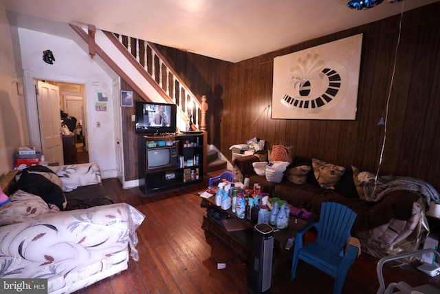 living room featuring lofted ceiling, dark wood-type flooring, and wood walls