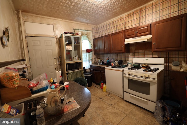 kitchen featuring light tile patterned floors, built in microwave, and white gas stove