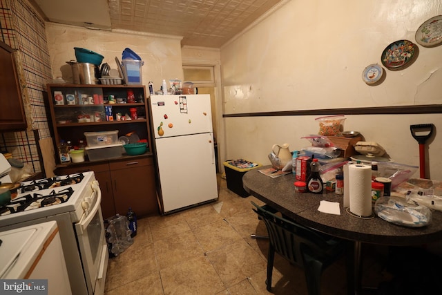 kitchen with crown molding and white appliances