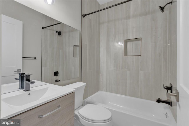 full bathroom featuring vanity, tiled shower / bath combo, and toilet