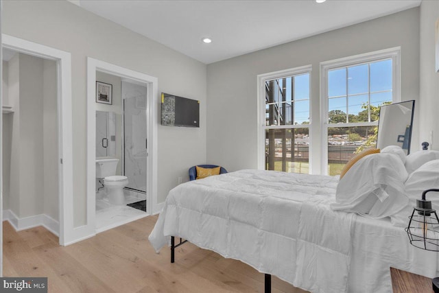 bedroom featuring ensuite bath and light hardwood / wood-style floors