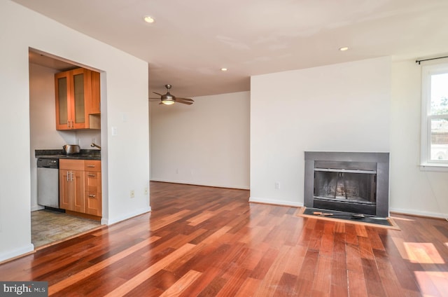 unfurnished living room featuring ceiling fan and light hardwood / wood-style floors