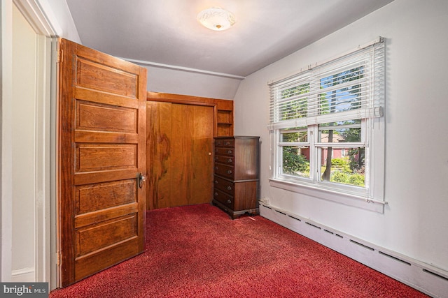 unfurnished bedroom featuring dark colored carpet, a closet, baseboard heating, and lofted ceiling