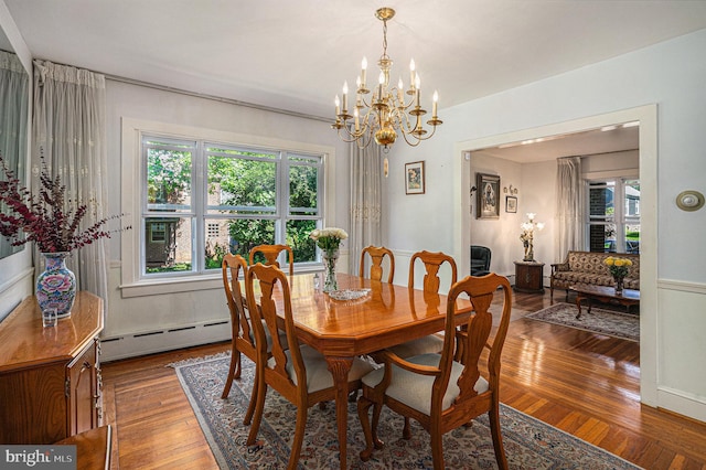 dining room featuring a chandelier, hardwood / wood-style floors, and a baseboard heating unit