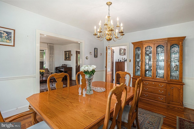 dining room with hardwood / wood-style flooring and an inviting chandelier