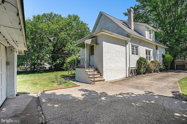 view of side of home with a yard