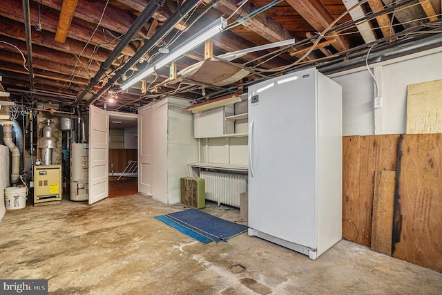 basement featuring gas water heater and white refrigerator