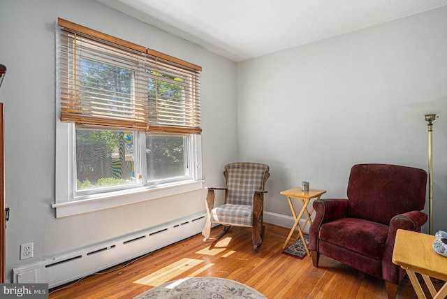 sitting room featuring light wood-type flooring and a baseboard heating unit