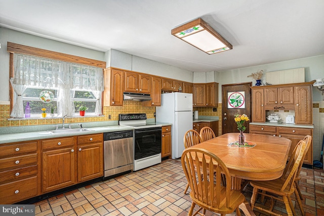 kitchen with white appliances, tasteful backsplash, and sink