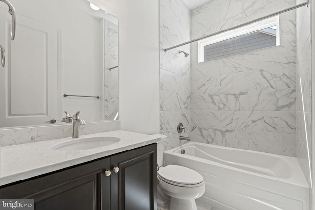 full bathroom with tiled shower / bath, vanity, and toilet