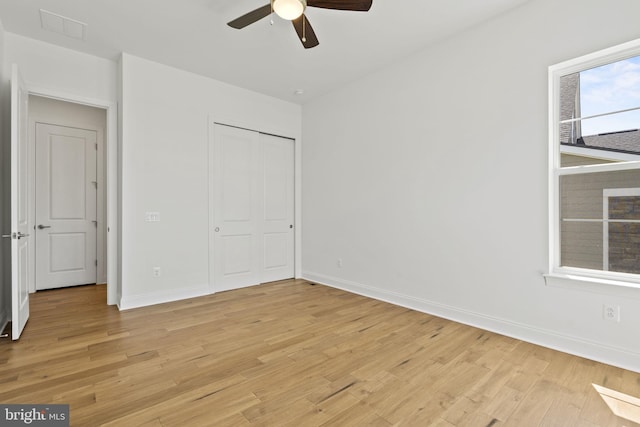 unfurnished bedroom featuring ceiling fan, a closet, and light hardwood / wood-style flooring